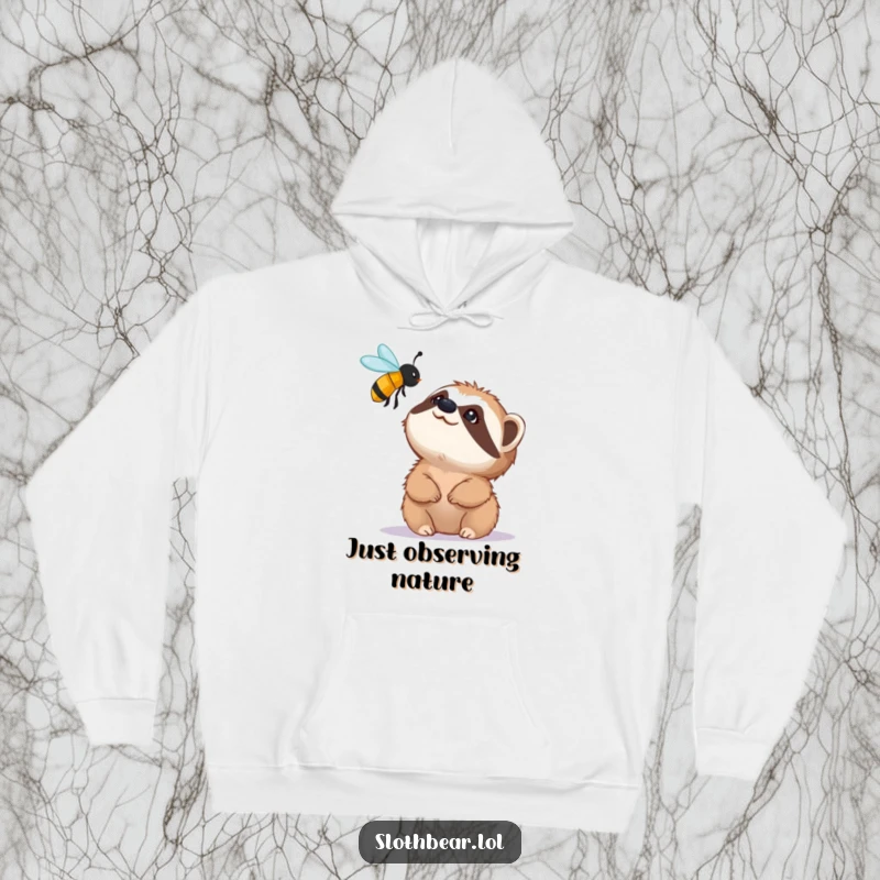 Funny hoodie showing a small sloth bear character looking up with fascination at a buzzing bee, offering cozy and humorous wildlife appreciation.